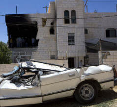A damaged car is seen outside the damaged family home of Amer Abu Aisheh, one of two Palestinians identified by Israel as suspects in the killing of three Israeli teenagers, after it was damaged by the Israeli army in the West Bank city of Hebron, Tuesday, July 1, 2014. (Oren Ziv/Activestills.org